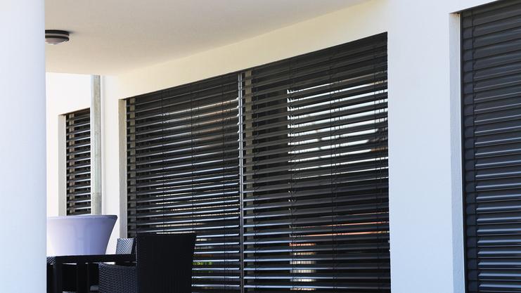 Sichtschutz und Sonnenschutz Rollade Große Fensterfront mit dunklem Rollo für Sichtschutz und Sonnenschutz