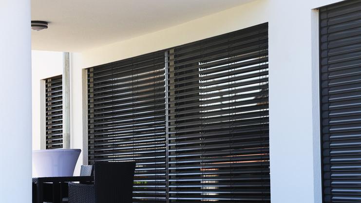 Große Fensterfront mit dunklem Rollo für Sichtschutz und Sonnenschutz