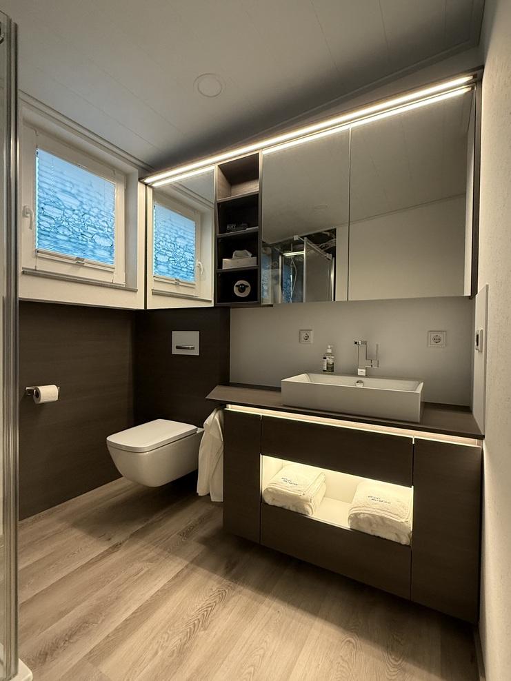 Eingebaute Badm&ouml;bel bestehend aus Waschtischunterschrank, Spiegelschrank, integration der Toilette it Wandverkleidungen