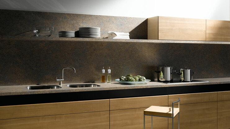 Küchenzeile aus Massivholz mit dunkler Arbeitsplatte Küchenzeile aus Massivholz mit schwarzer Arbeitsplatte, Spülbecken und Wandregal